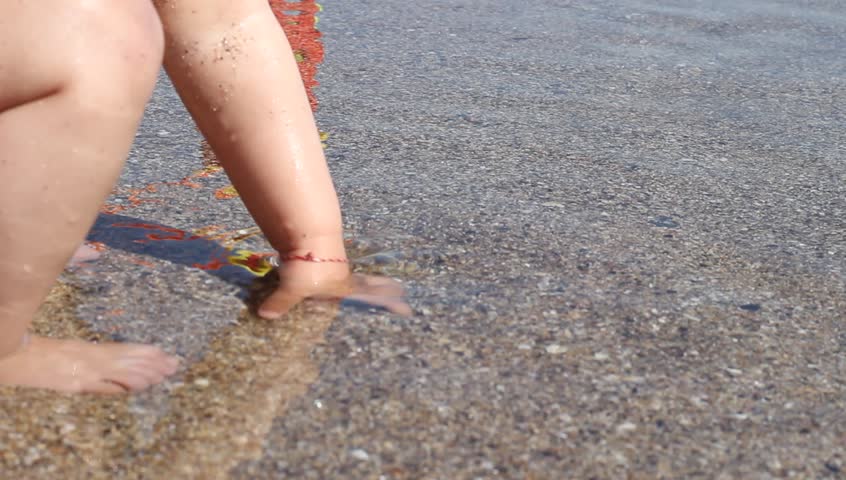 Slow Motion Shot Of A Childs Bare Feet Walking On Seaside Rocks With