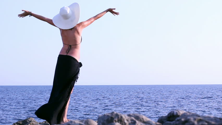 Young Woman Standing On Cliffs Edge And Looking To A Ocean With Raised Hands Stock Footage