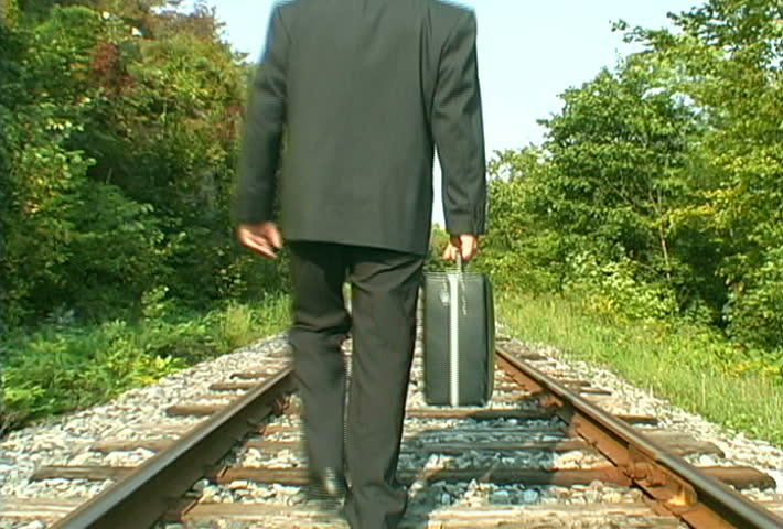 Video Of A Business Man Walking On A Railroad Track At The Middle Of