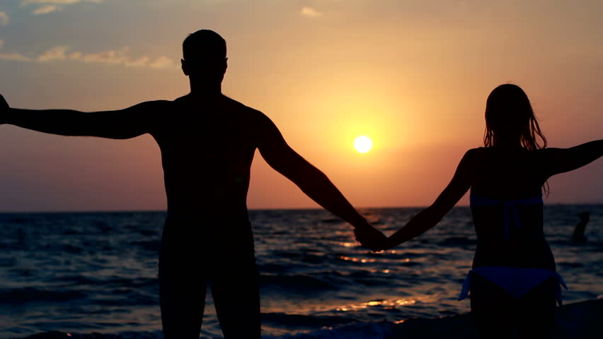 Romantic Couple On Beach Walks Into Sunset Holding Hands Hd Stock