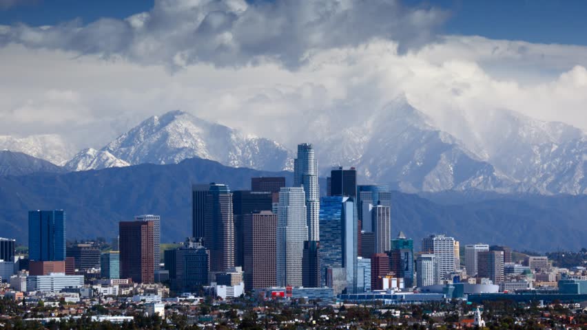 Los Angeles City Skyline Over Snowy Mountains. Zoom-in On Downtown 