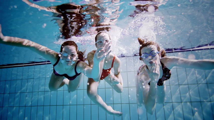Young Female Friends In A Swimming Pool Having Fun Together Underwater