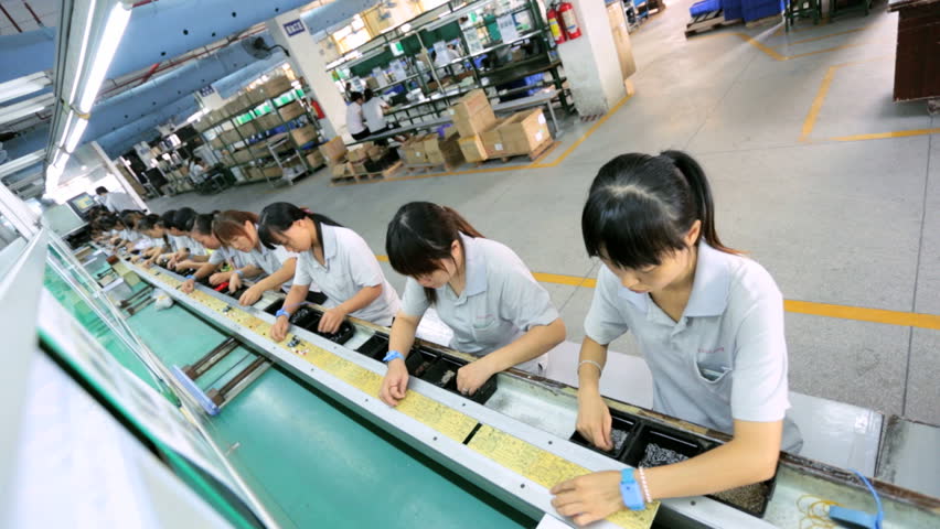 China October 2013 Assembly Line Factory Worker Welding Parts On Assembly Line For Global 