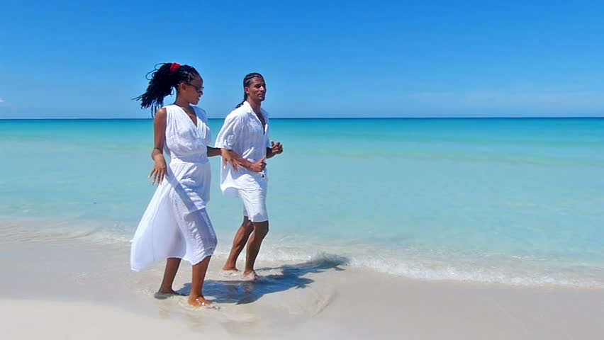 Young Happy African American Couple Dancing Salsa At A Tropical Beach