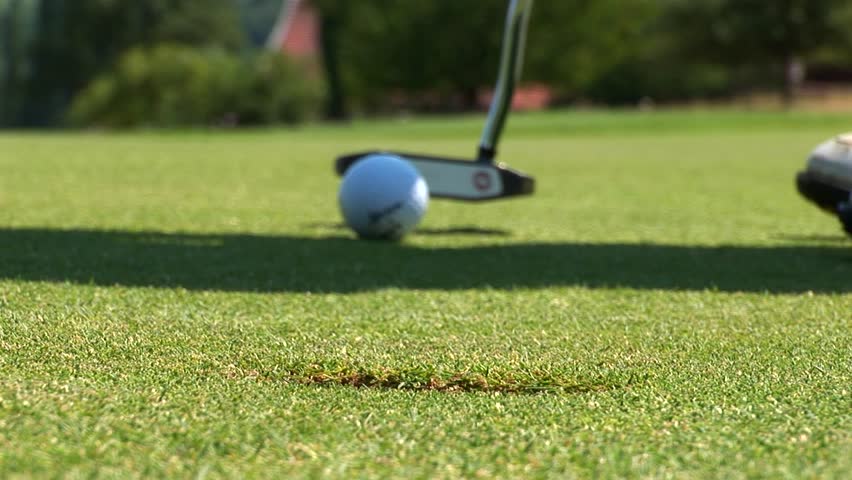 Close Up Of A Golf Ball Being Hit By A Club On The Grass, In Slow ...