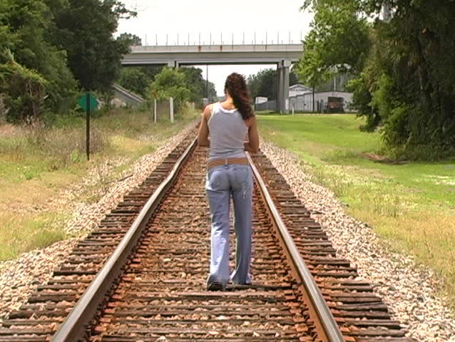 A beautiful Latina brunette walks away from the camera down a lonely ...