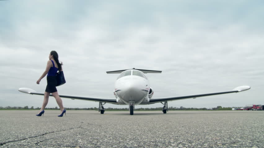 Girl Walks Across A Runway Infront Of A Private Jet. Long Shot From ...