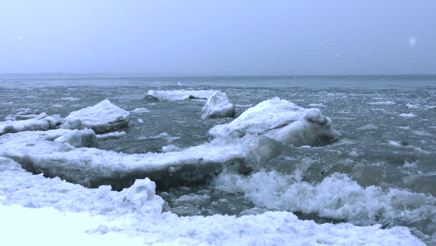 Icy Frozen Waves Crash Onto A Frozen Shoreline, Breaking Off Pieces And ...