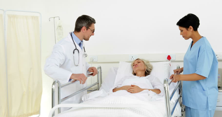 Two Doctors Visiting An Unconscious Patient At The Hospital Stock ...